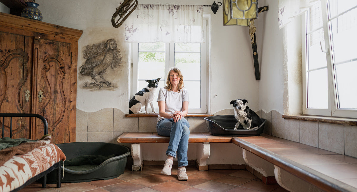Cloud7 founder Petra Jungebluth sitting on a bench with two shelter dogs at ProAnimale