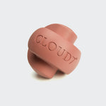 CLOUD7_ Das Beschäftigungsspielzeug Zeno Faded Rose ist ein rosafarbener Gummiball mit sich kreuzenden Bändern und CLOUD7-Prägung; dieses robuste Spielzeug dient auch als Leckerli-Spender, abgebildet auf einem schlichten hellen Hintergrund.