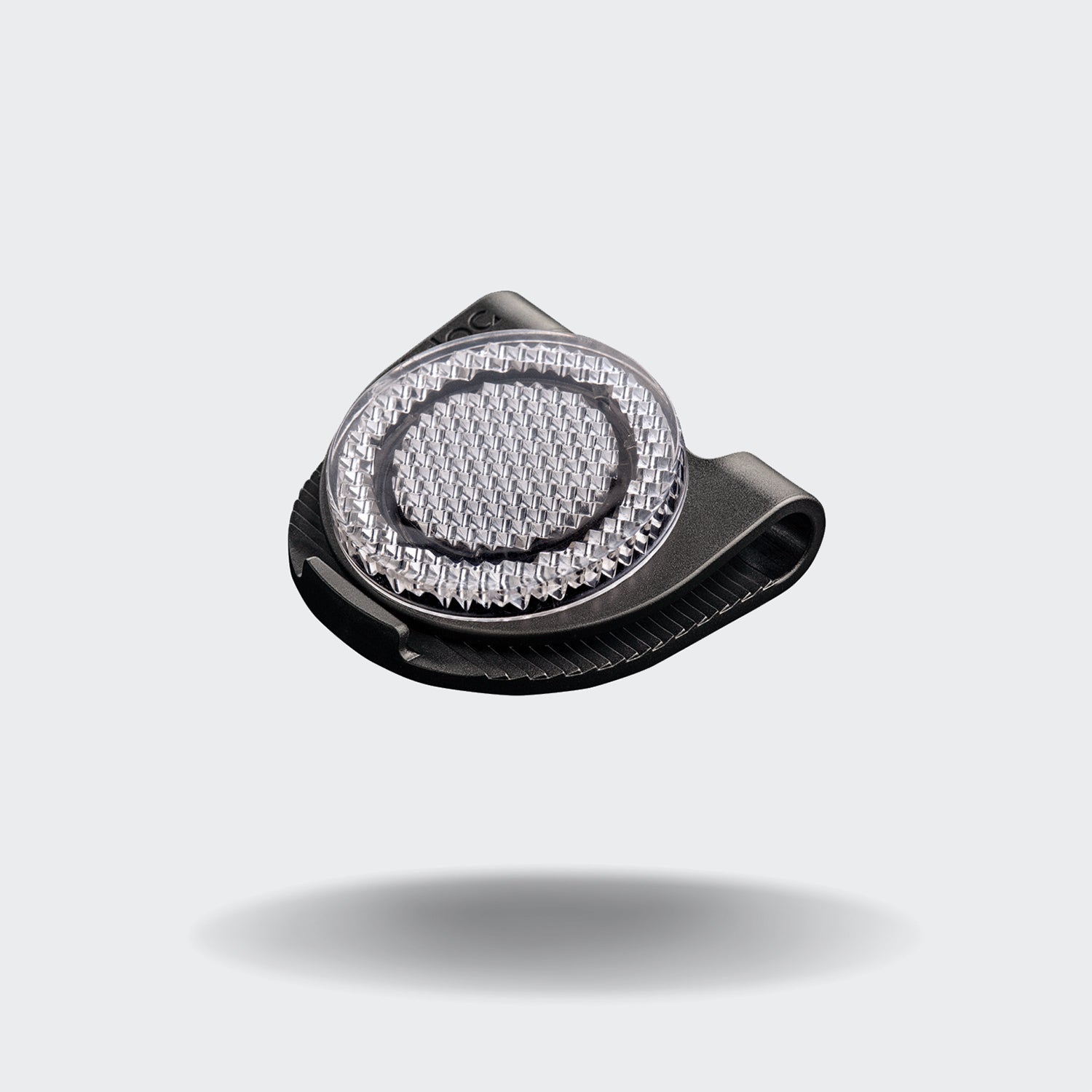 CLOUD7_ Der Orbiloc® Reflective Clip, ein kleines schwarzes Accessoire mit einer strukturierten silbernen Mitte, verbessert die Sichtbarkeit im Dunkeln und ist auf einem schlichten hellgrauen Hintergrund mit einem weichen Schatten darunter abgebildet.