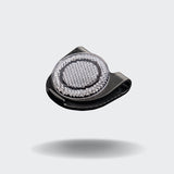 CLOUD7_ Der Orbiloc® Reflective Clip, ein kleines schwarzes Accessoire mit einer strukturierten silbernen Mitte, verbessert die Sichtbarkeit im Dunkeln und ist auf einem schlichten hellgrauen Hintergrund mit einem weichen Schatten darunter abgebildet.