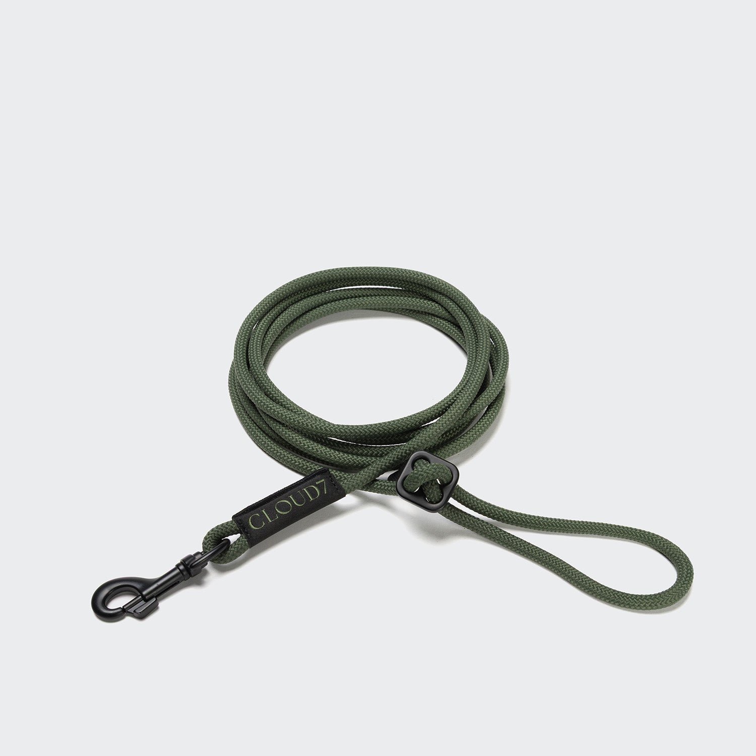 CLOUD7_ Die Seilleine LTTL Dark Olive ist eine aufgerollte, olivgrüne Leine mit schwarzem Metallclip und dem Label "CLOUD7". Mit einem verstellbaren Schlaufengriff und einem minimalistischen Design ist sie ideal für kleine Hunde.