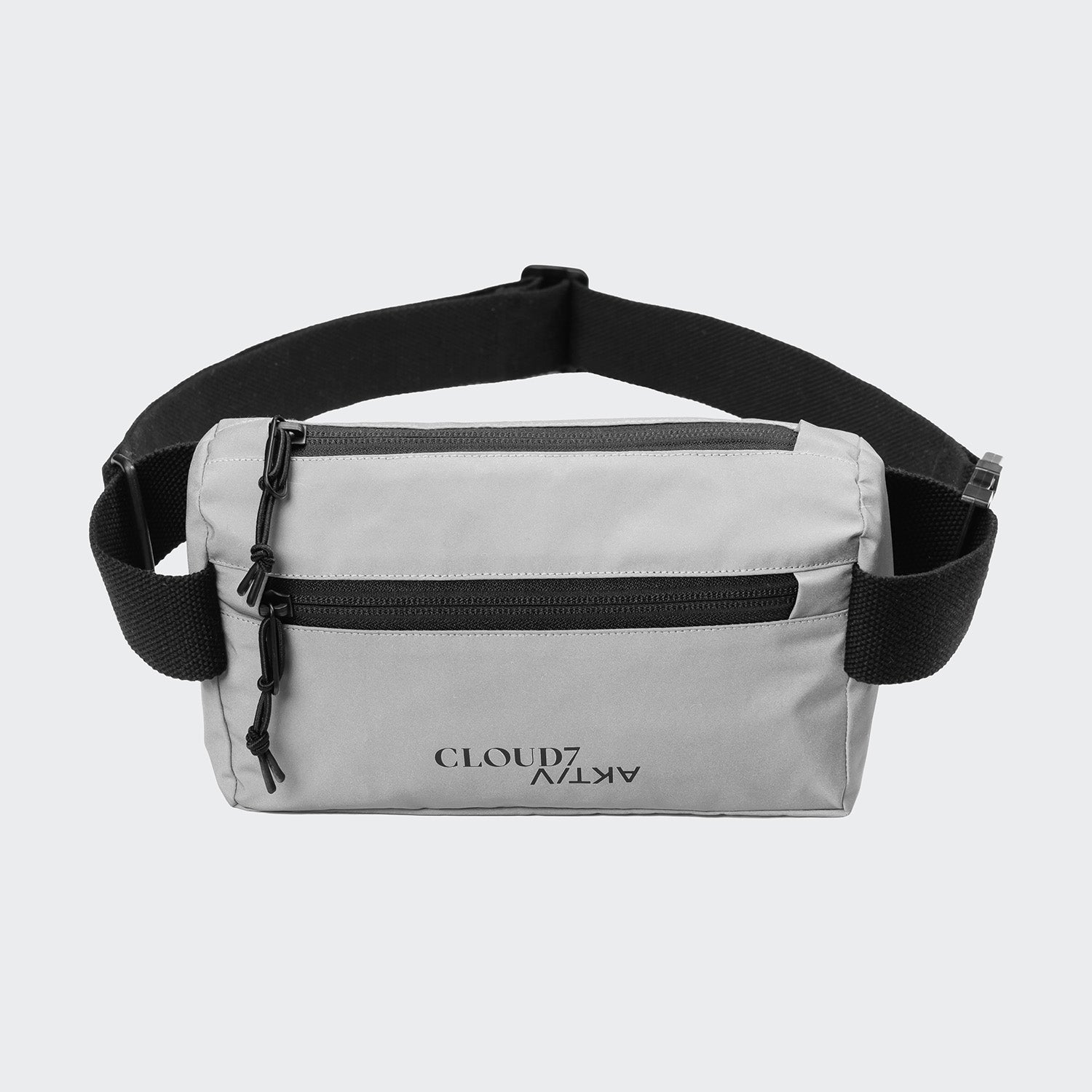 CLOUD7_ Die Gürteltasche AKTIV Reflective hat hellgraues, reflektierendes Material, einen schwarzen, verstellbaren Riemen, zwei Reißverschlussfächer und CLOUD7 ART/LY in schwarzer Schrift auf der Vorderseite.