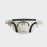CLOUD7_ Die Gürteltasche AKTIV Sand ist eine beigefarbene Hüfttasche mit schwarzem Besatz, grünen Reißverschlüssen an mehreren Fächern, einem schwarzen Karabiner auf der linken Seite - ideal als Hundetrainingszubehör - und dem Aufdruck "CLOUDY AZLV" in Schwarz auf der Vordertasche.