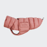 CLOUD7_ Der Hundemantel Alaska Faded Rose ist ein rosafarbener Wintermantel für Hunde mit einem Reißverschluss oben, Seitentaschen und Öffnungen für Kopf und Beine. Abgebildet auf einem schlichten hellgrauen Hintergrund.