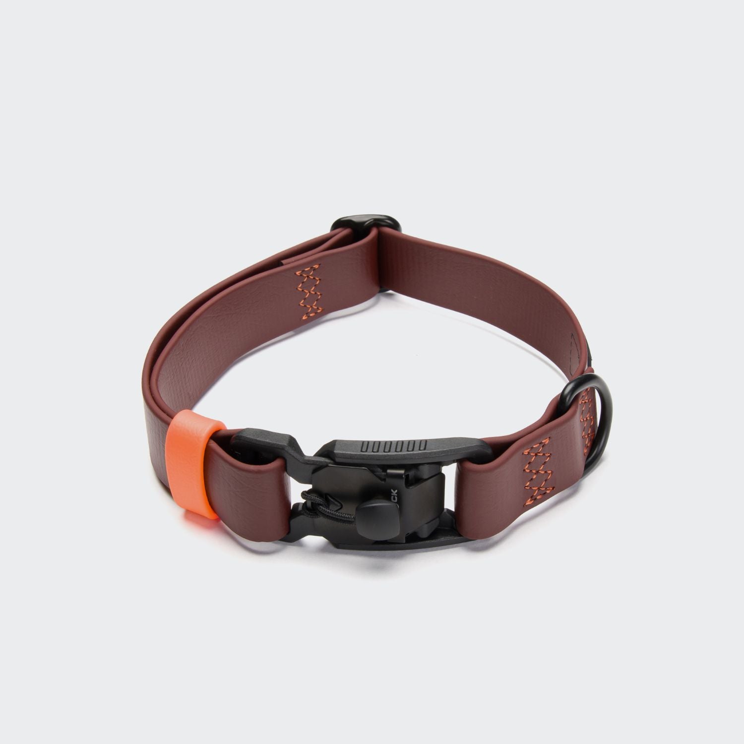 CLOUD7_ Das Hundehalsband BioThane Ipanema Dark Aubergine mit schwarzer Kunststoffschnalle, orangefarbener Akzentschlaufe und D-Ring aus Metall ist auf einem schlichten hellgrauen Hintergrund abgebildet. Dieses wasserfeste Halsband bietet sowohl Stil als auch Haltbarkeit für Ihren Hund.