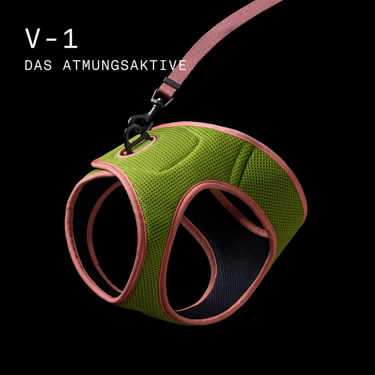 CLOUD7_ Atmungsaktives Tiergeschirr in Grün und Rosa mit Netzdesign, befestigt an einer rosa Leine, dargestellt vor schwarzem Hintergrund. Oben links ist in weißer Schrift der deutsche Text „V-1 DAS ATMUNGSAKTIVE“ zu lesen.