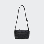 CLOUD7_ Die RESC7UE Leckerlitasche Plush Anthra ist eine kleine, rechteckige, strukturierte schwarze Crossbody-Tasche mit einem verstellbaren Riemen, einer Reißverschlusstasche auf der Vorderseite und einem Reißverschluss mit rundem Etikett, der vor einem einfarbigen hellgrauen Hintergrund abgebildet ist.
