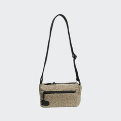 CLOUD7_ Die RESC7UE Leckerlitasche Plush Sandy Brown ist eine beigefarbene Bouclé-Kreuztasche mit einem schwarzen, verstellbaren Riemen und Reißverschlüssen auf der Vorder- und Oberseite, die auf einem schlichten hellgrauen Hintergrund abgebildet ist.